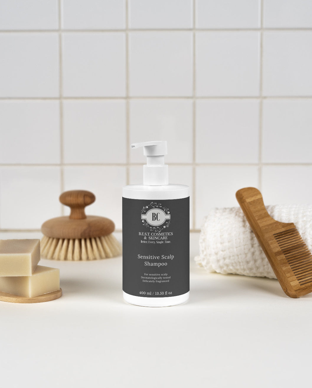 Bottle of shampoo with a brush and soap on a tiled bathroom counter
