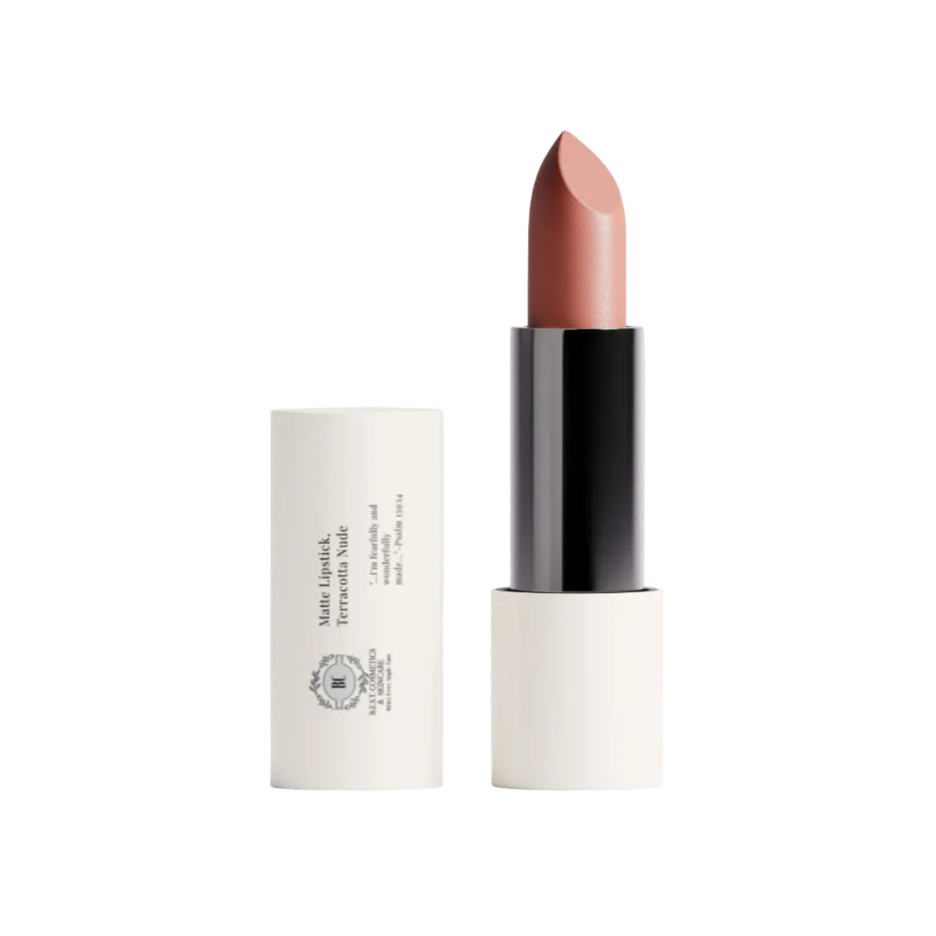 A nude lipstick in a warm dusty rose shade, shown with its black and white cylindrical packaging on a clean white background.